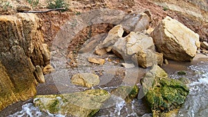 Large yellow sand stones boulders rocks on sandy beach of the sea shore. Natural