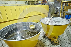 Large yellow vats with glaze for the process of glazing of gingerbread.