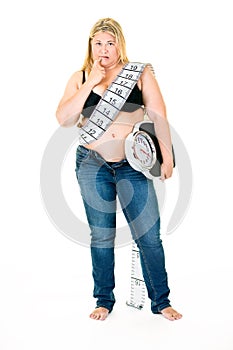 Large young woman with weighing scales under arm