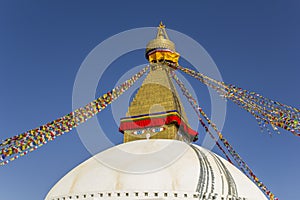 The largest Tibetan Buddhist stupa in the world Bodnath in Kathmandu with colorful prayer flags and eyes against the background of