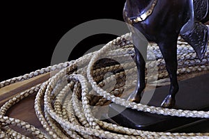 Lariat rope isolated with horse statue forelegs and stirrup. Text space. photo