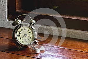 Larm clock and white headphones on a wooden desk for a relaxing holiday