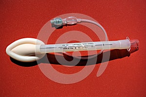 Laryngeal mask airway for emergency medical help on a red background