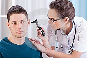 Laryngologist examining patient ears