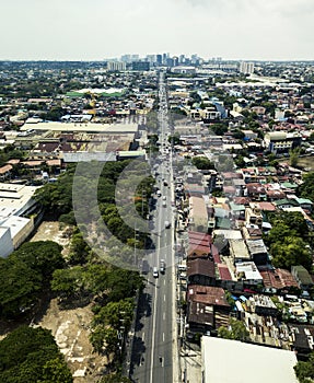 Las Pinas, Metro manila - Aerial of Alabang Zapote Road in center, with Alabang skyline in background