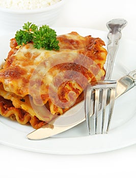 Lasagna with Fork and Knife on White