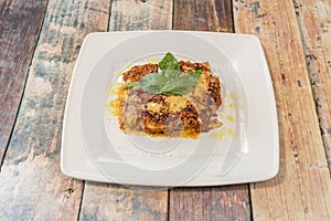 Lasagna recipe with gluten-free pasta, grated cheese, tomato, beef stew and basil leaves