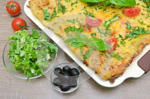 Lasagna, tomatoes, olives and salad Friese