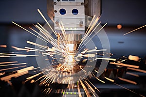 Laser cutting. Metal machining with sparks on CNC laser engraving maching