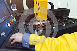 Laser cutting and the operator at the control panel, CNC modern industrial technology