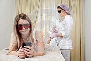 Laser hair removal for legs: young woman reclines at a reputable beauty salon