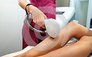 Laser ipl device in cosmetician hand. Woman body hair removal. Cosmetology leg technology