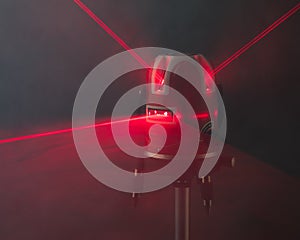 Laser level tool red light beams in smoke