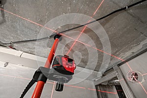 Laser measurement during renovation. Construction tools and equipment. Red laser light lines for level measure.