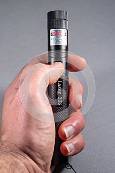 laser pointer 303 in black metal in green light.  hand to hold.