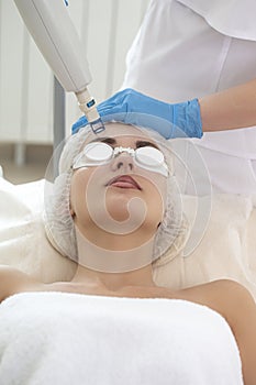 Laser Procedures Ideas. Caucasian Woman Getting Cosmetology Laser Facial Beauty Treatment While Removing Pigmentation in Clinic