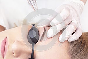 Laser removal of permanent eyebrow makeup. A young woman undergoes laser removal of permanent makeup in a salon. photo