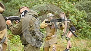 Laser tag game. Soldiers are aiming. Men plays airsoft in the forest. Martial law. Medium shot.