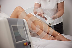 laser treatment, leg at spa, female cosmetologist