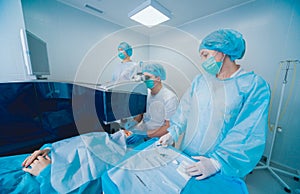 Laser vision correction. A patient and team of surgeons in the operating room