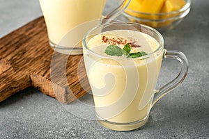 Lassi mango. Traditional Indian drink, gray background. Summer refreshing smoothie. Side view, selective focus