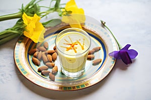 lassi surrounded by mango and almonds