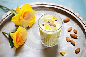 lassi surrounded by mango and almonds