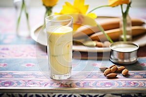 lassi surrounded by mango and almonds