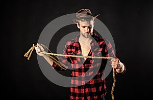 Lasso is used in rodeos as part of competitive events. Lasso can be tied or wrapped. Western life. Man unshaven cowboy photo