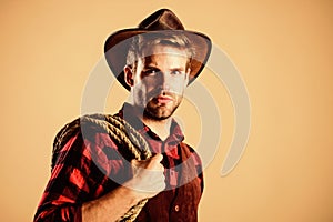 Lasso is used in rodeos part competitive events. Lasso can be tied or wrapped. Western life. Man cowboy beige background