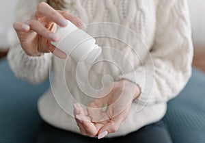 Last antibiotic tablet - a woman pours the last medicine from the package into the palm of her hand. Treatment with