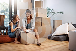 The last box. Full length shot of an attractive young woman and her daughter moving into a new house.