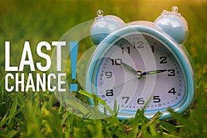 Last Chance, Business Concept - text showing Last Chance with a clock on grass photo