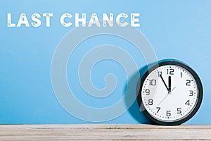 Last chance words on blue colored background with clock