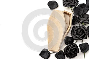 Last goodbye, grief for the deceased and sadness of losing loved ones concept with wood coffin surrounded by black roses isolated