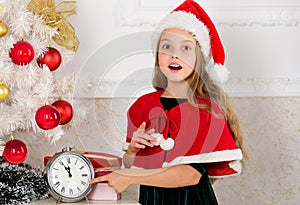Last minute new years eve plans that are actually lot of fun. Girl kid santa hat costume with clock counting time to new photo