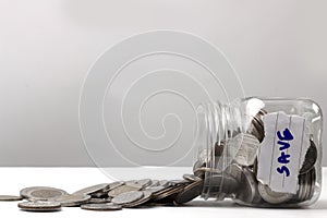 Last money in tin can close up, many silver and golden coins currency spread out on white table, hard times and inflation,