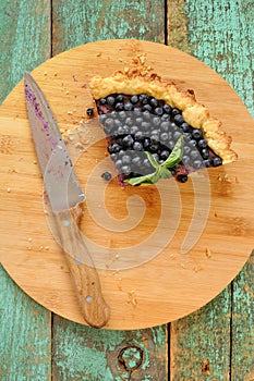 Last piece of homemade open pie decorated with fresh forest blue