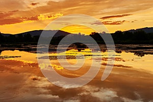 Beautiful summer golden sunset with colorful water surface.