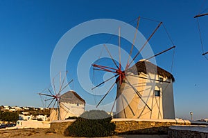 The last rays of the sun over White windmills on the island of Mykonos, Greece