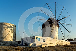 The last rays of the sun over White windmills on the island of Mykonos, Greece