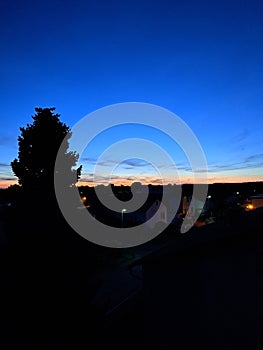 Last seconds of a sunset in loweraustria with a tree and Houses