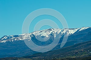 Last snow in the mountains in early spring against a clean blue sky