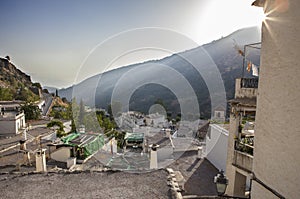 Last sun rays falling over Pampaneira town hills photo