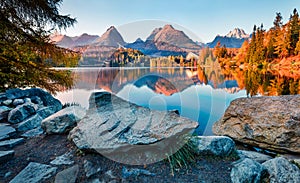 Last sunlight glowing of mountain hills on Strbske pleso lake. Exciting evening scene of High Tatras National Park, Slovakia, Euro