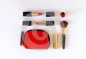 Lat lay of beauty cosmetic make up products in red, black and gold color knolled on white background.