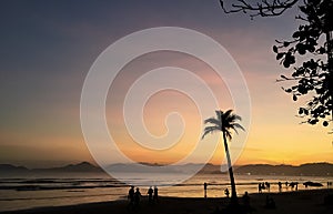 Late afternoon in the city of Santos, Brazil, with tourists walking on the beach