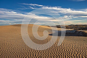 The late afternoon sun casts shadows across the sand dunes at Adolfo Lopez Mateos in Baja California photo