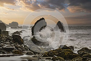 Late afternoon sun rays glinting off the crashing waves of Muir Beach in California