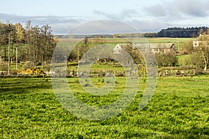 Late autumn. An abandoned farm in the middle of green pastures.